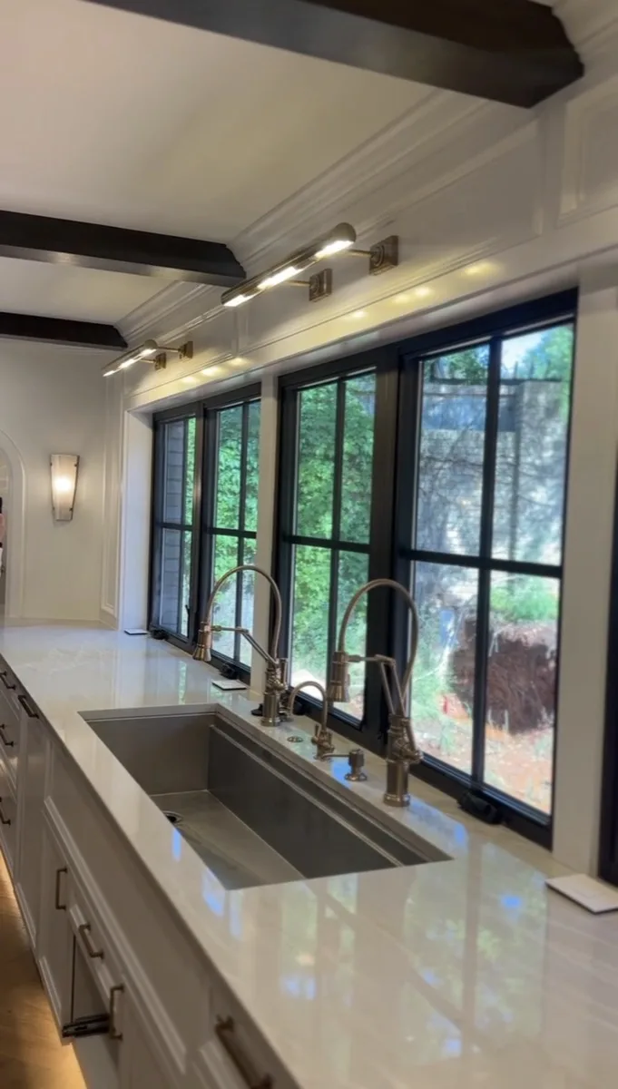 Arched stained glass window with fluted sconce lighting in a home
