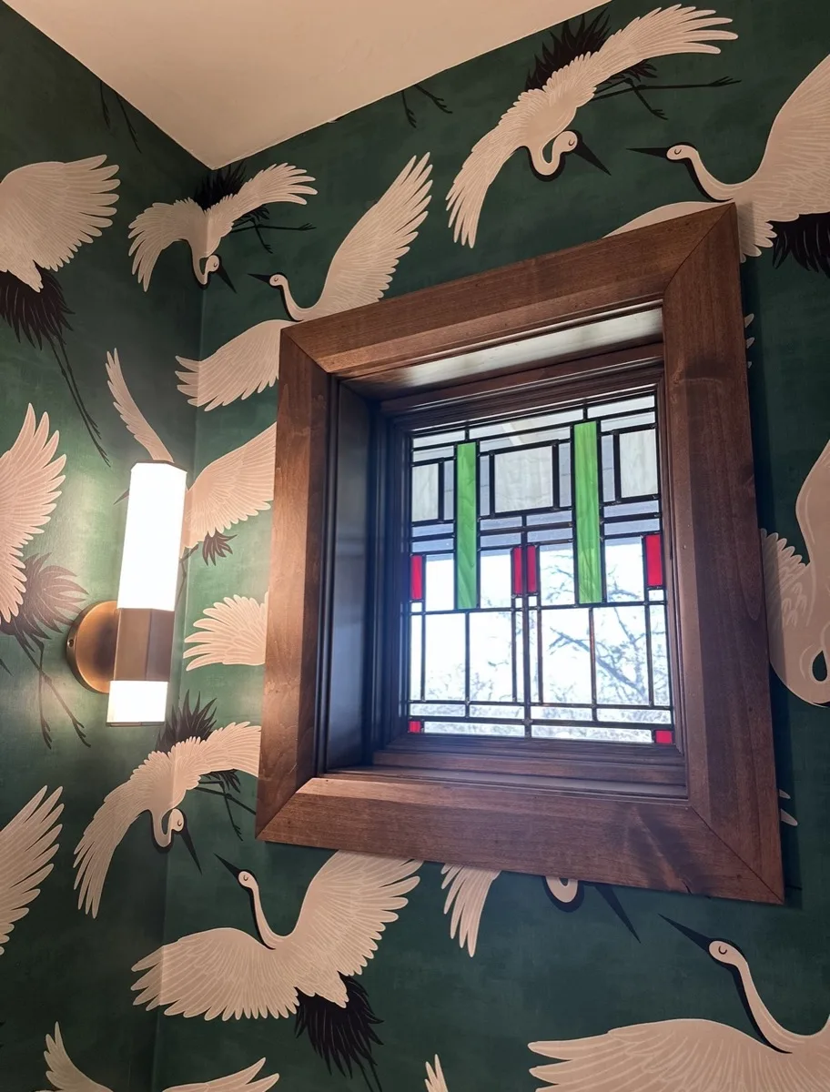 Stained glass window with sconce lighting in a home