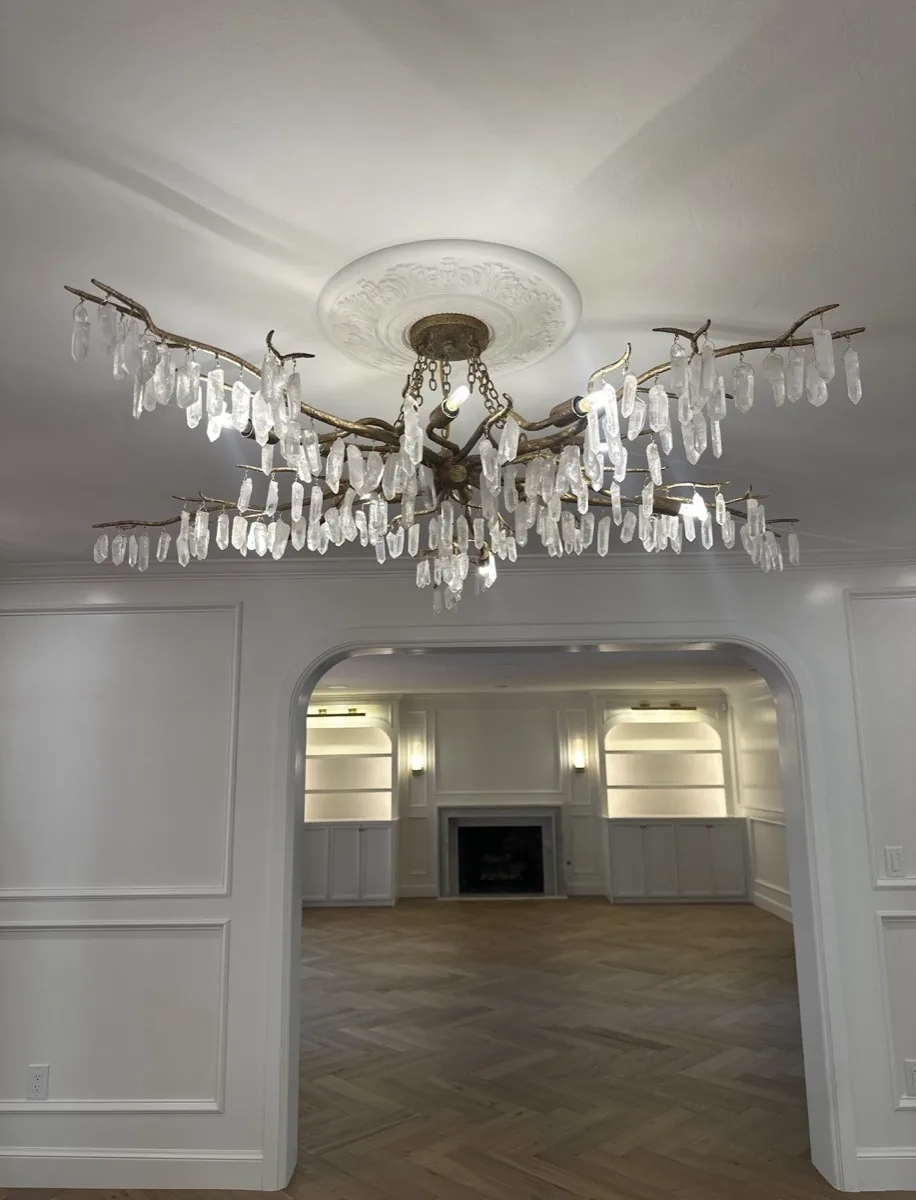 Crystal branch chandelier in a dining and living room archway in a home