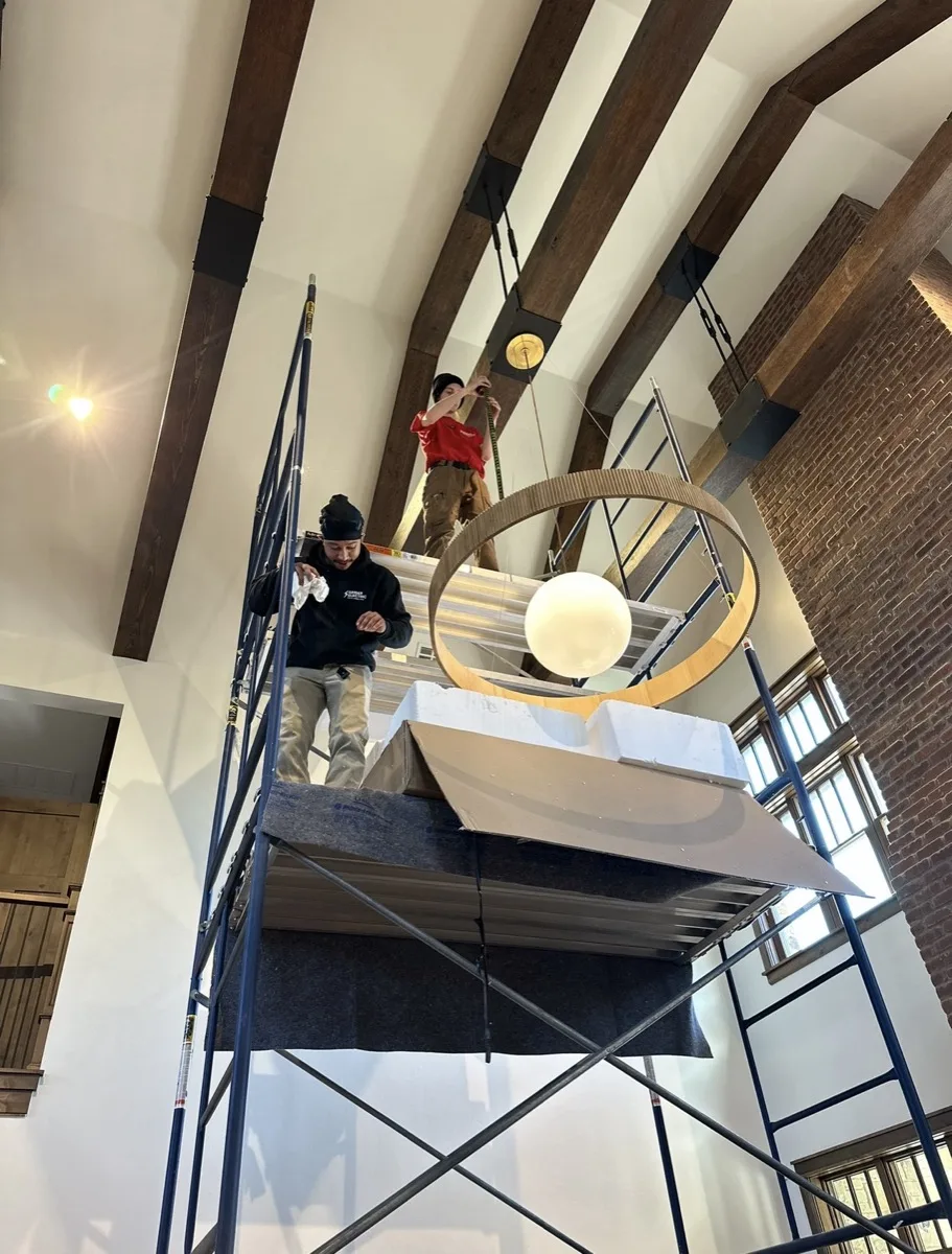 Grider Electric electricians installing a statement chandelier in an OKC home