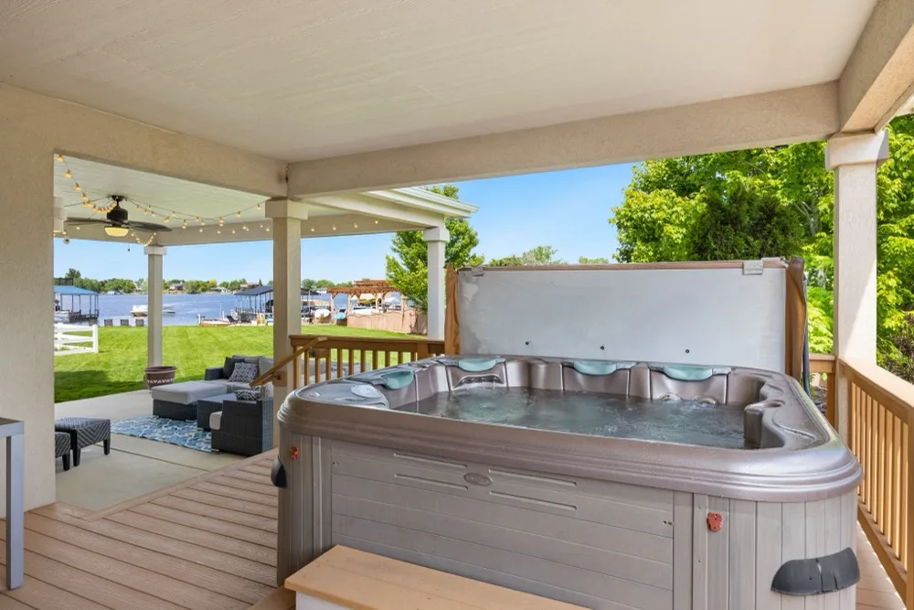 Hot tub on a covered backyard deck overlooking a lake