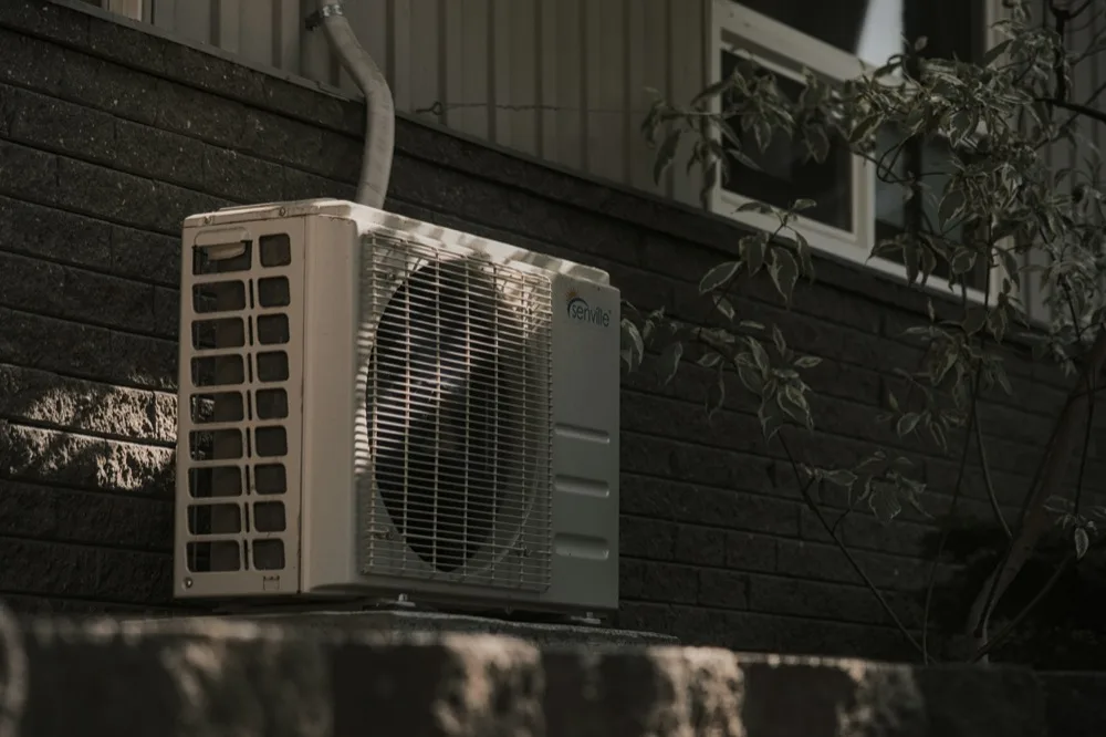 Ductless mini-split condenser unit outside a home