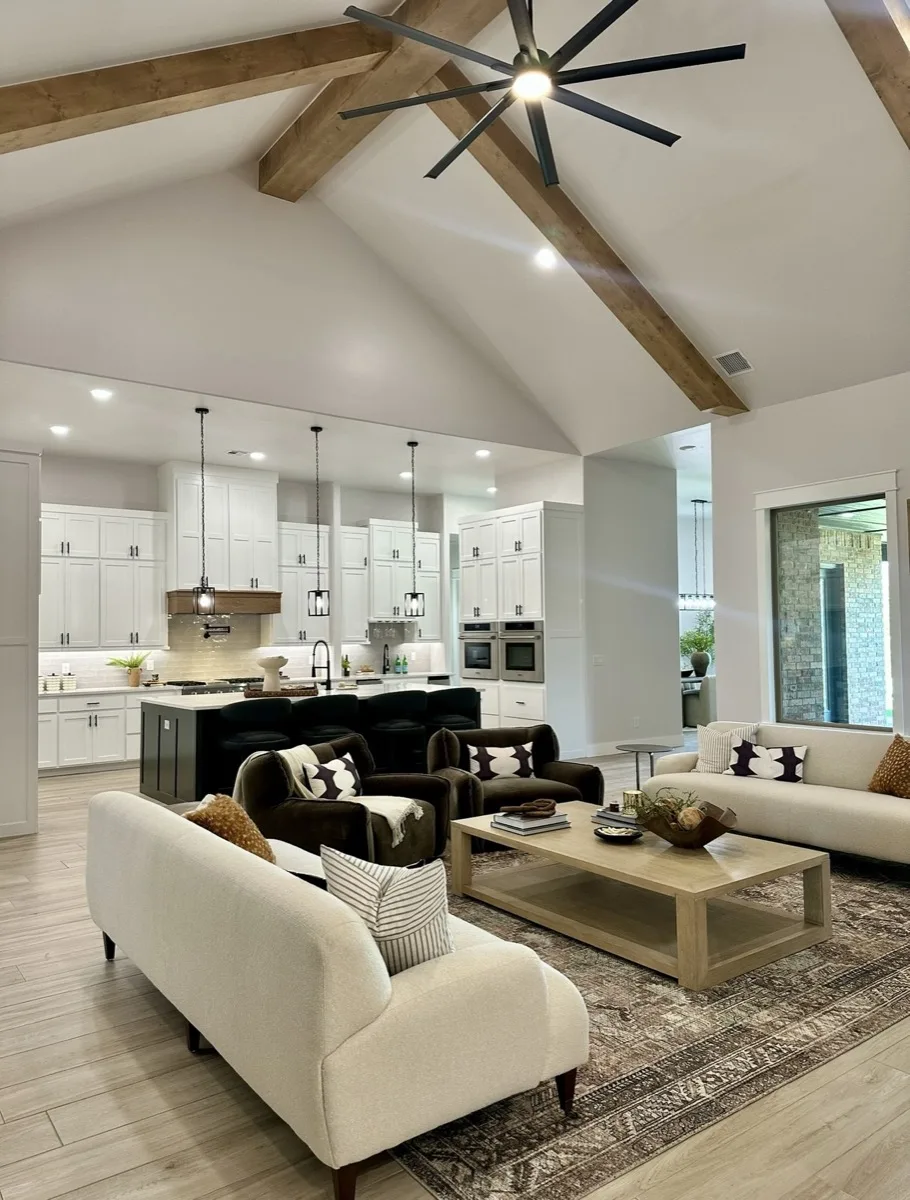 Vaulted living room with statement ceiling fan in a home