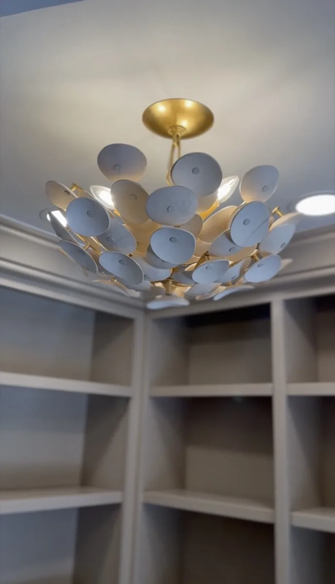 Scalloped flush-mount ceiling light in a built-in bookshelf nook in a home